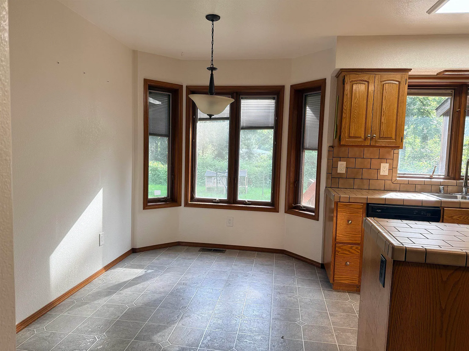 Dining area with bay windows letting in late-afternoon light.